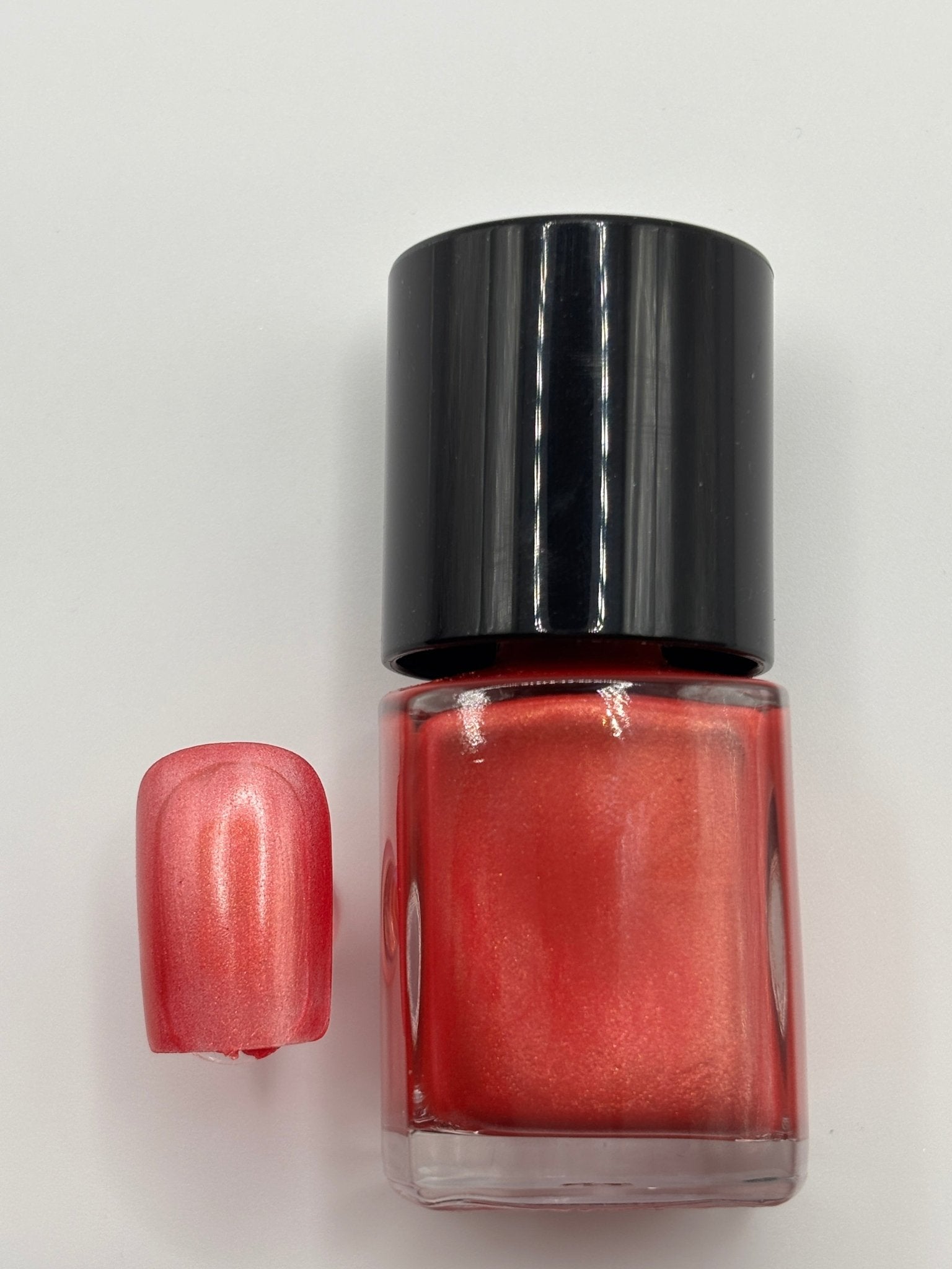 bottle of Berniece and fake nail beside it