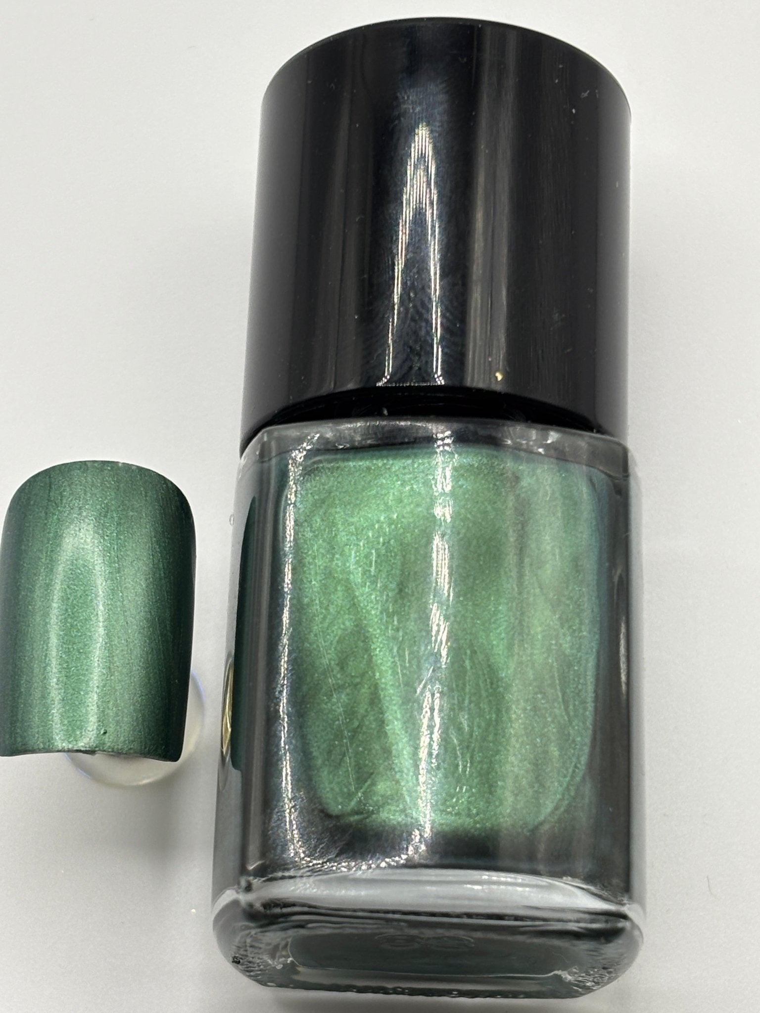 BOTTLE OF DR FRENCH WITH NAIL BESIDE THE BOTTLE WITH THE SAME COLOR AS THE BOTTLE