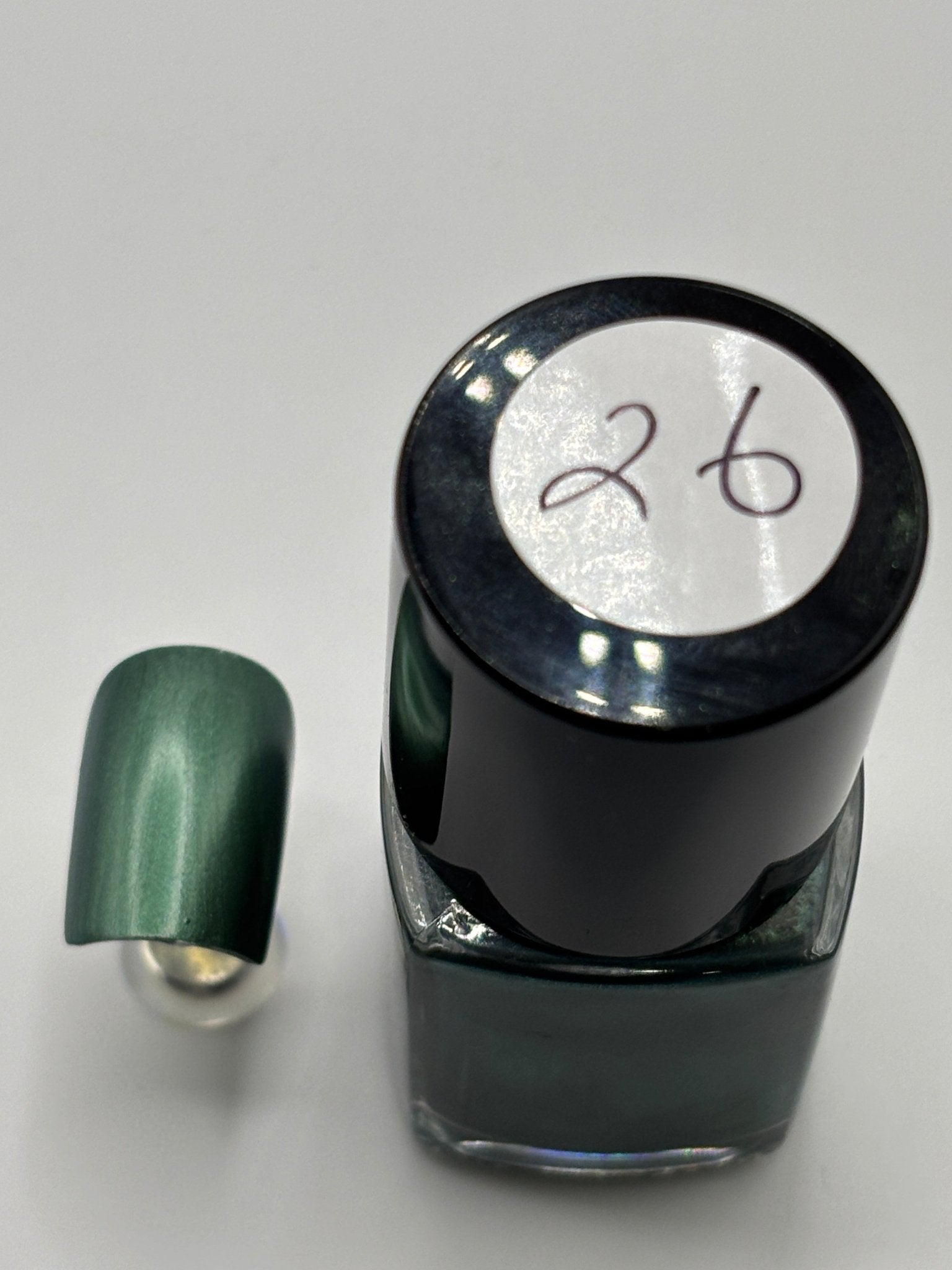 BOTTLE OF DR FRENCH WITH NAIL BESIDE THE BOTTLE WITH THE SAME COLOR AS THE BOTTLE WITH THE NUMBER 26 ON THE BOTTLE