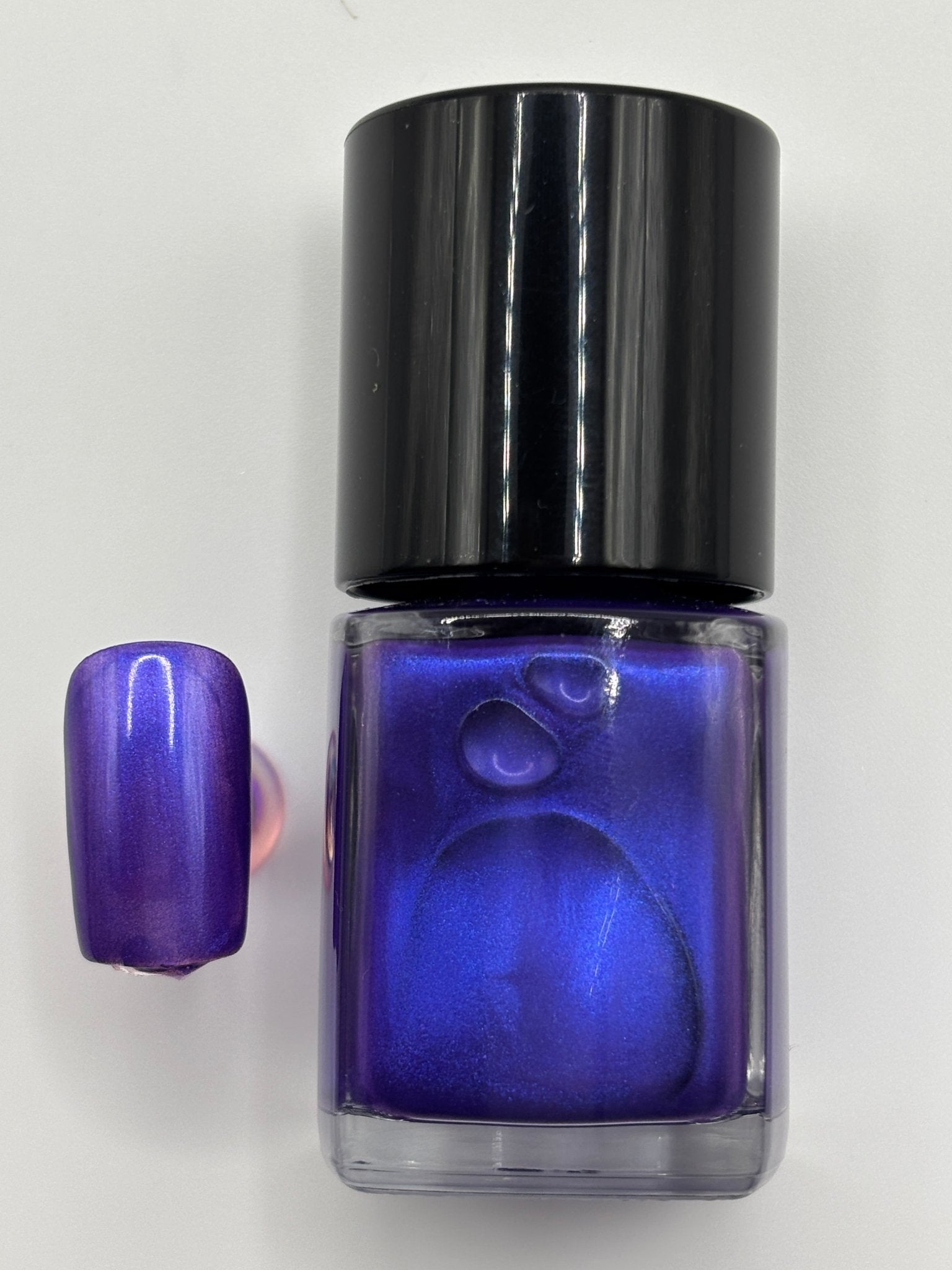 BOTTLE OF VALENCIA WITH NAIL BESIDE IT THE SAME COLOR