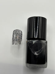 A BOTTLE OF MOLLY BLACK GLITTER POLISH WITH A FAKE FINGERNAIL WITH MOLLY ON IT